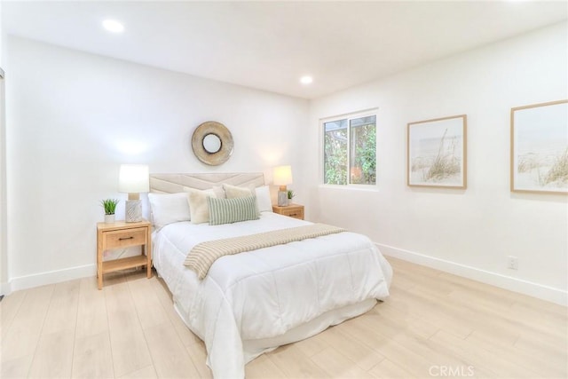 bedroom with light wood finished floors, baseboards, and recessed lighting