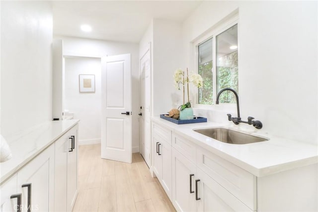 bar featuring a sink, light wood-style floors, and recessed lighting