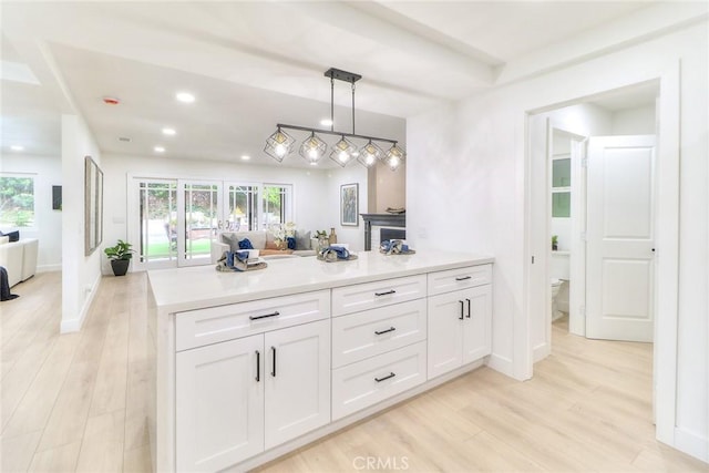 kitchen with light wood-style flooring, white cabinetry, recessed lighting, light countertops, and baseboards
