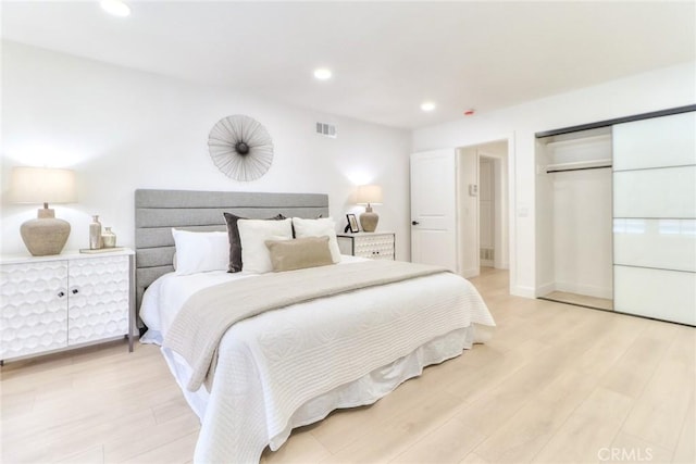 bedroom featuring light wood-style flooring, recessed lighting, and a closet