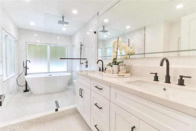 bathroom featuring a freestanding tub, double vanity, a shower, and recessed lighting