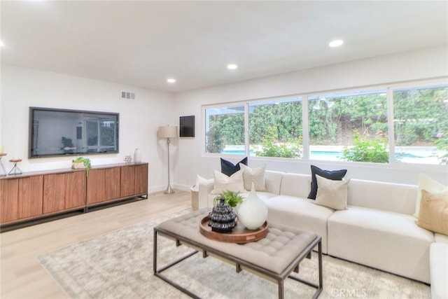 living area featuring light wood-style flooring, recessed lighting, and baseboards