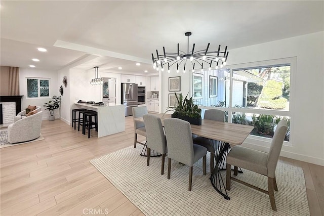 dining room with a chandelier, light wood-style flooring, recessed lighting, and baseboards