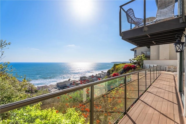 balcony featuring a water view and a beach view
