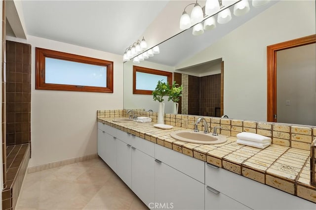full bath with double vanity, baseboards, tile patterned flooring, and a sink