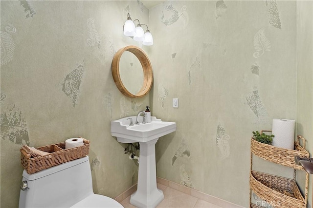 half bath featuring toilet, baseboards, and tile patterned floors