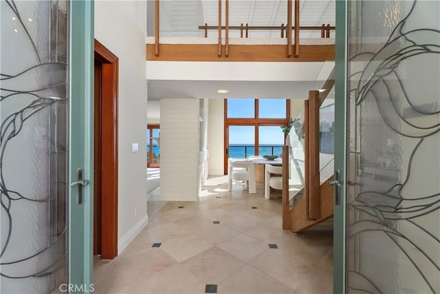 bathroom with a water view, baseboards, french doors, and tile patterned floors