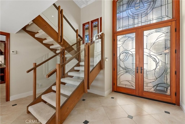 entrance foyer with tile patterned flooring, stairs, baseboards, and french doors