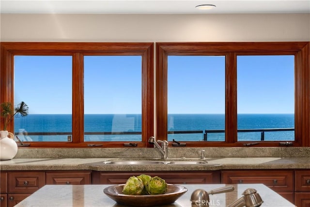 kitchen featuring a sink, a water view, and a healthy amount of sunlight