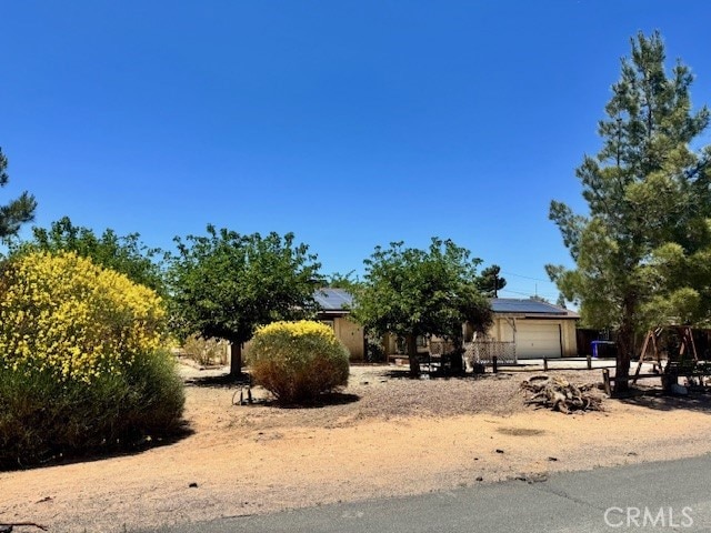 14122 Pawnee Rd, Apple Valley, CA 92307 - view of property hidden behind natural elements featuring an attached garage and solar panels