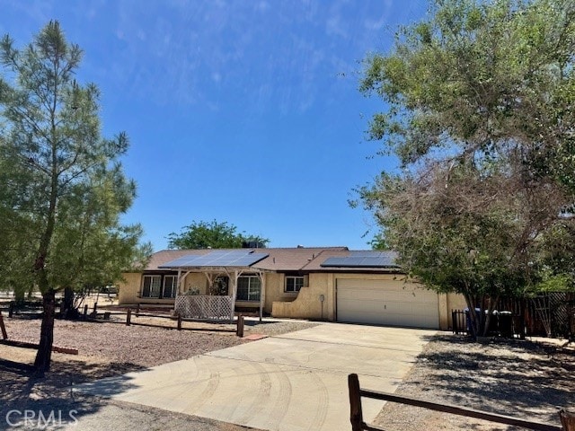 14122 Pawnee Rd, Apple Valley, CA 92307 - single story home featuring a garage, fence, driveway, solar panels, and stucco siding