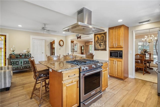 11300 Dulcet Ave, Porter Ranch, CA 91326 - kitchen featuring stainless steel appliances, island range hood, light stone counters, a breakfast bar area, and light wood-style flooring