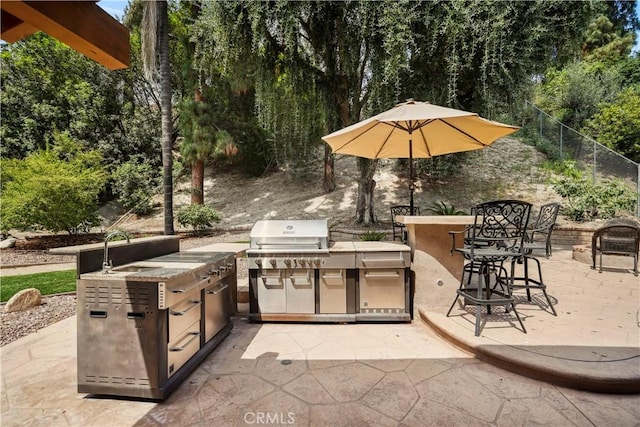 11300 Dulcet Ave, Porter Ranch, CA 91326 - view of patio / terrace with exterior kitchen and view of wooded area