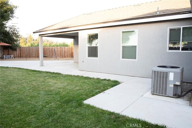 exterior space with central AC unit, a fenced backyard, and a patio
