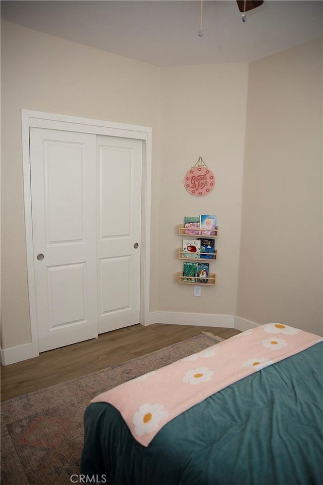 bedroom featuring baseboards, a closet, and wood finished floors