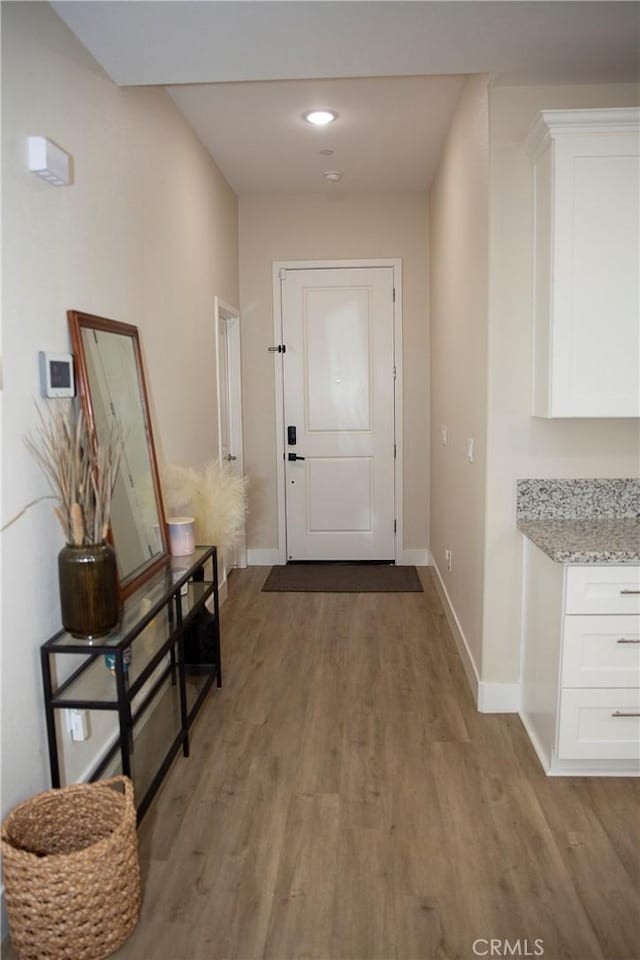 doorway to outside with baseboards, light wood-style flooring, and recessed lighting