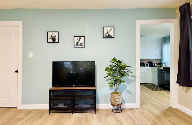 living area featuring light wood finished floors and baseboards