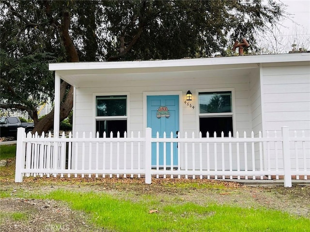 view of front of property featuring a porch and fence