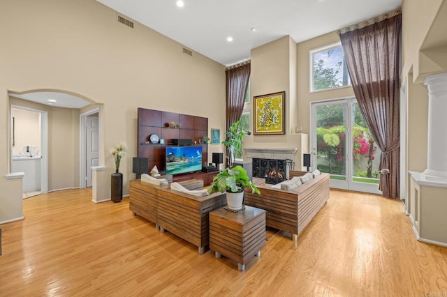 3358 Caminito Luna Nueva, Del Mar, CA 92014 - living room with a towering ceiling, arched walkways, a lit fireplace, light wood-style floors, and recessed lighting