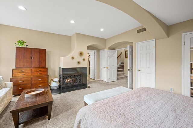 3358 Caminito Luna Nueva, Del Mar, CA 92014 - bedroom featuring arched walkways, light carpet, recessed lighting, and a fireplace with flush hearth