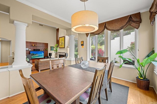 3358 Caminito Luna Nueva, Del Mar, CA 92014 - dining area with ornate columns, wood finished floors, a warm lit fireplace, crown molding, and baseboards