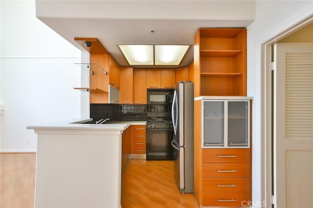 7100 La Tijera Blvd Unit B202, Los Angeles, CA 90045 - kitchen featuring light wood-style flooring, open shelves, black appliances, and tasteful backsplash