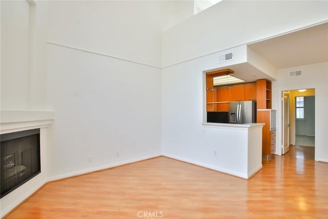 7100 La Tijera Blvd Unit B202, Los Angeles, CA 90045 - unfurnished living room with light wood finished floors, visible vents, a fireplace, and baseboards