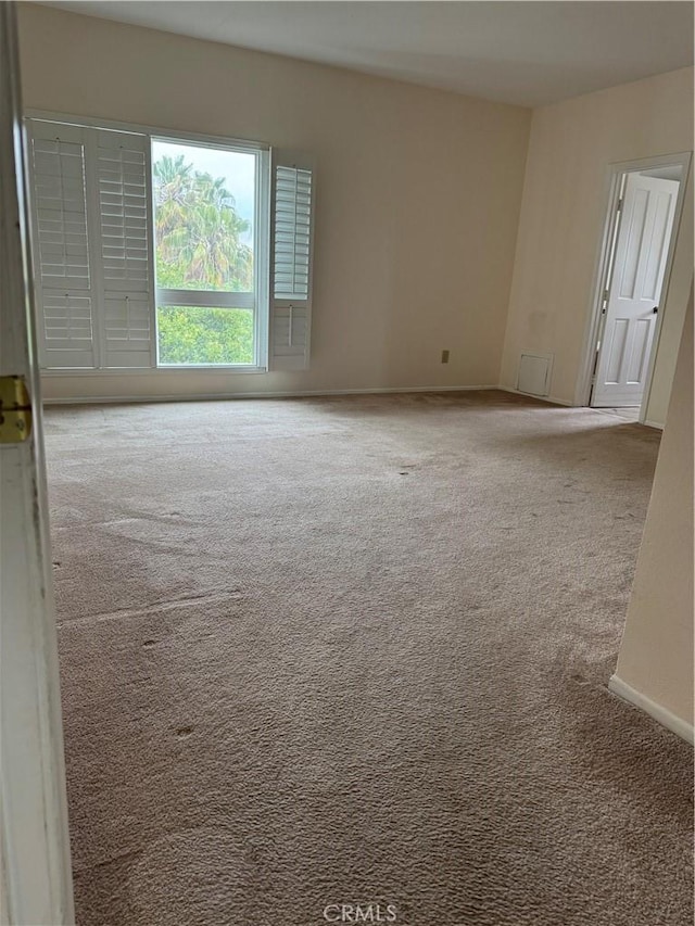 unfurnished room with baseboards and carpet floors