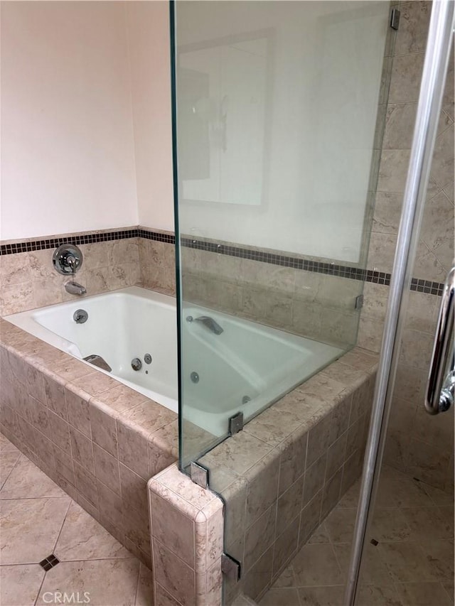 bathroom with tile patterned flooring, a jetted tub, and a shower stall