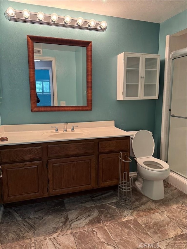 full bathroom with vanity, toilet, and a stall shower