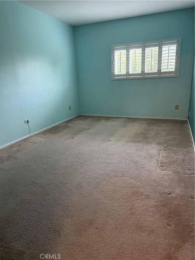 carpeted spare room with baseboards