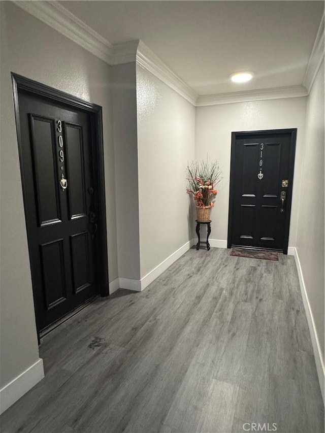 entryway with baseboards, crown molding, and wood finished floors