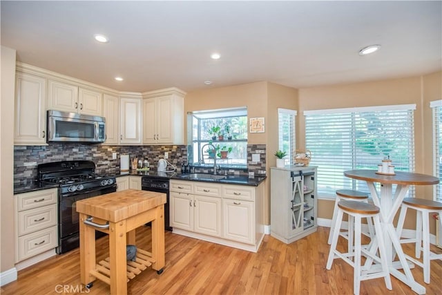 3251 Mountainside Dr, Corona, CA 92882 - kitchen featuring black appliances, a sink, dark countertops, light wood-style floors, and backsplash