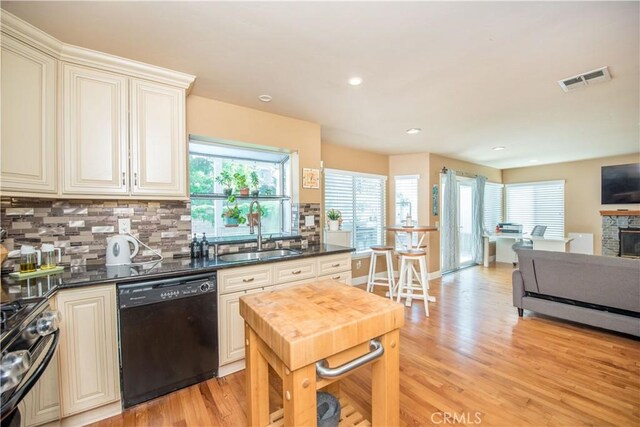 3251 Mountainside Dr, Corona, CA 92882 - kitchen featuring black appliances, a sink, light wood-style flooring, dark countertops, and decorative backsplash