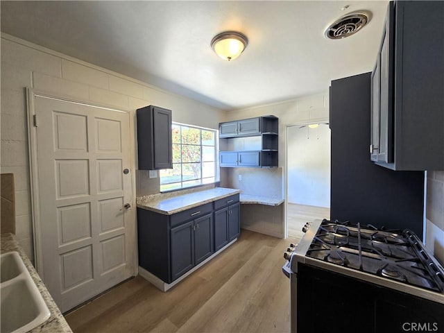 kitchen with light countertops, visible vents, light wood-style flooring, and stainless steel gas stove