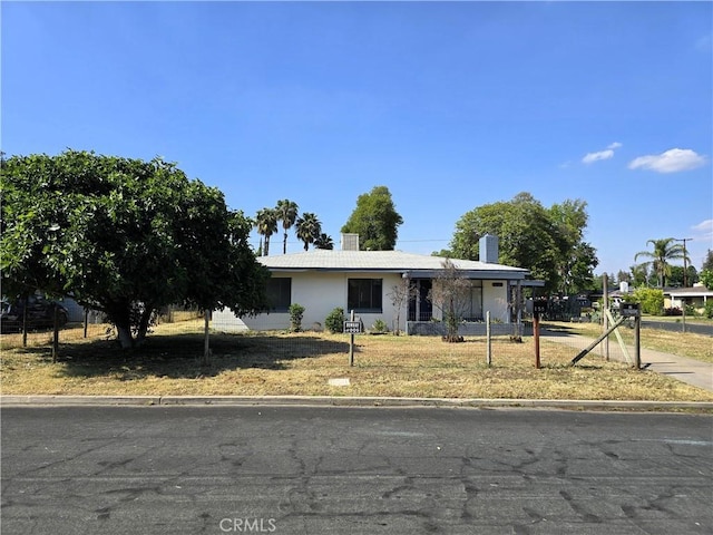 view of front of property with a chimney and a front lawn