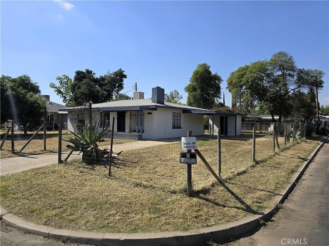 ranch-style house with a chimney and fence