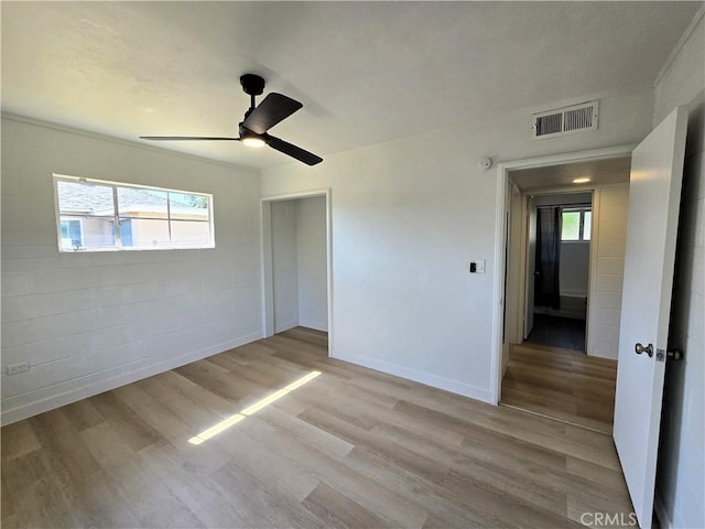 unfurnished room with ceiling fan, baseboards, visible vents, and wood finished floors