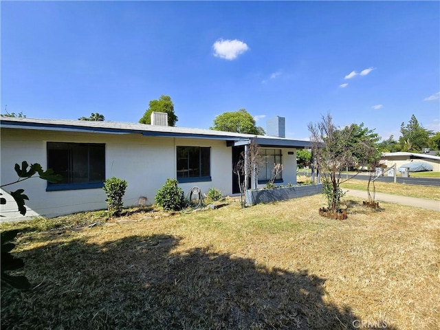 view of front of house featuring a chimney and a front yard