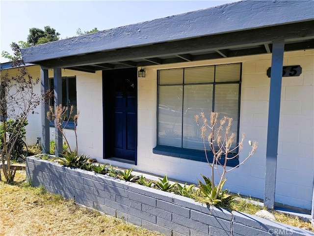 view of exterior entry featuring concrete block siding