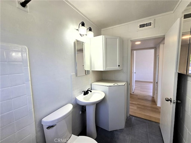 bathroom featuring tile patterned flooring, toilet, and visible vents