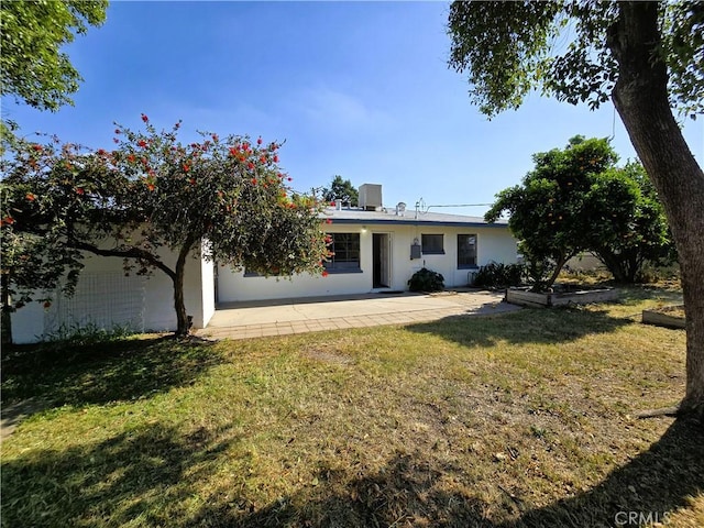 rear view of house featuring a yard and a patio area