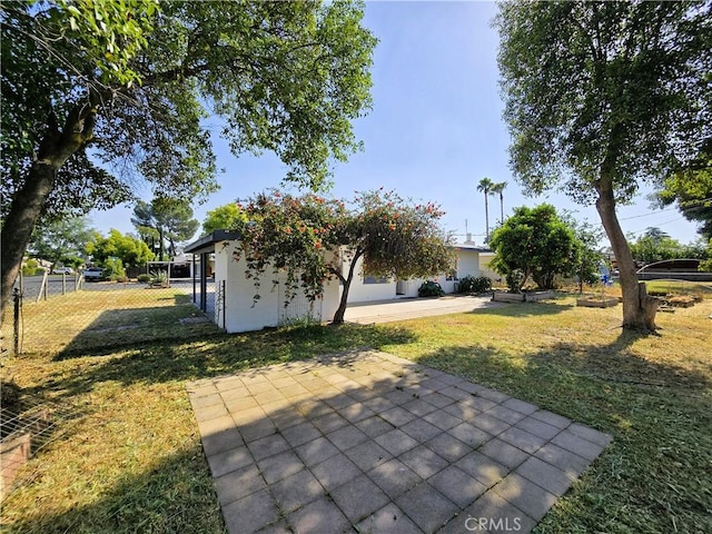 exterior space featuring a lawn, a patio, and fence