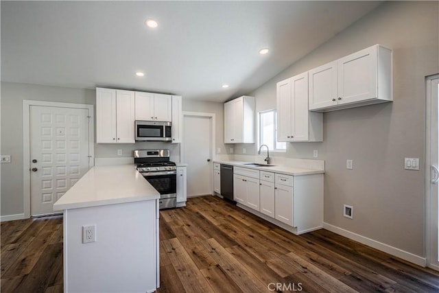 kitchen featuring a peninsula, stainless steel appliances, white cabinets, and a sink