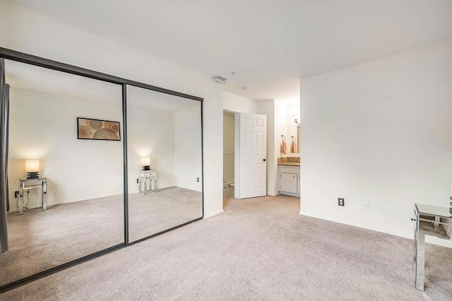 5704 Camino Del Cielo Unit 502, Bonsall, CA 92003 - unfurnished bedroom with baseboards, a closet, ensuite bath, and light colored carpet