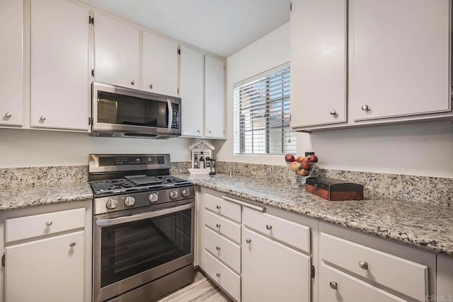 5704 Camino Del Cielo Unit 502, Bonsall, CA 92003 - kitchen featuring appliances with stainless steel finishes, light stone countertops, and white cabinetry