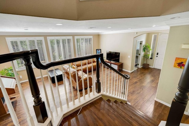 stairway featuring crown molding, wood finished floors, and baseboards