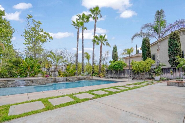 outdoor pool with a patio and a fenced backyard