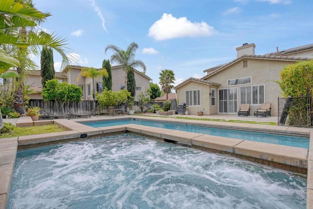 view of swimming pool featuring an in ground hot tub, a fenced in pool, a fenced backyard, and a patio