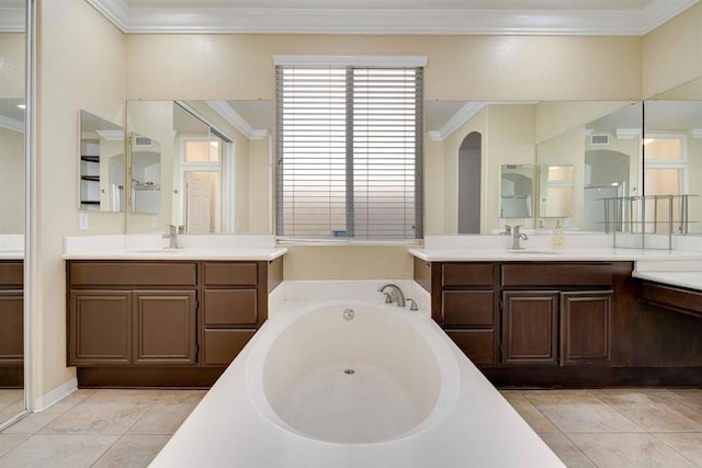 bathroom featuring a garden tub, visible vents, ornamental molding, and a sink